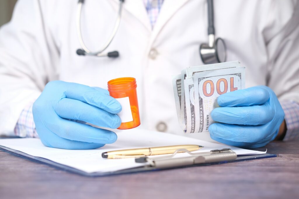 doctor hands in gloves holding prescription pills and US dollars money